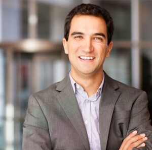 a smiling man wearing a formal suit attire